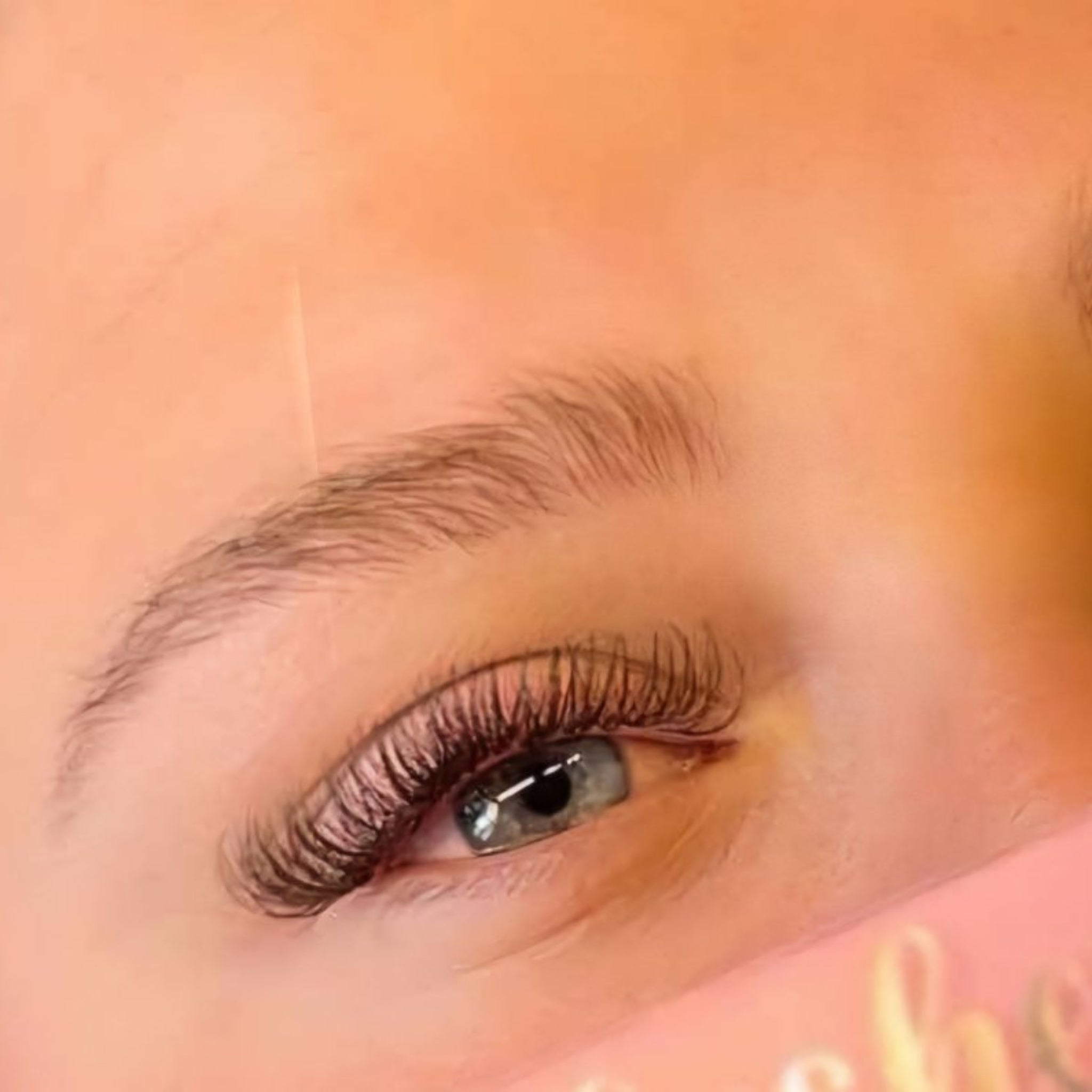 Completed brown Fairy lash extension set on blue eyes showing full dense volume and warm brown tone from front angle