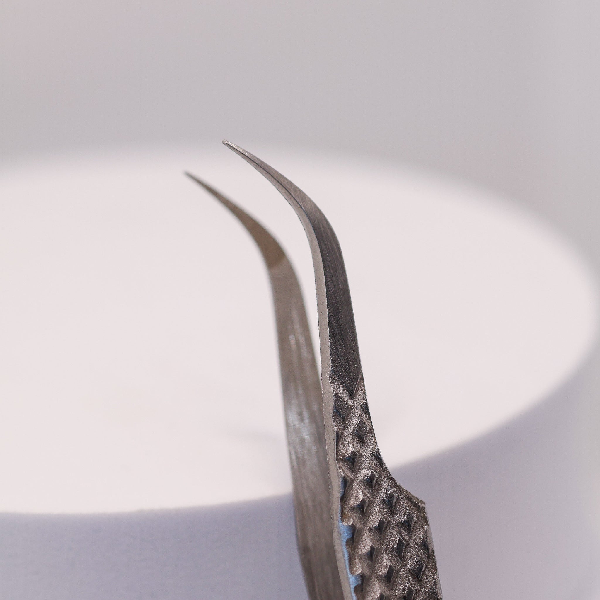Close-up of LADYBUGLASHES All Purpose Curved 60° Tweezers – fibre grip tip detail