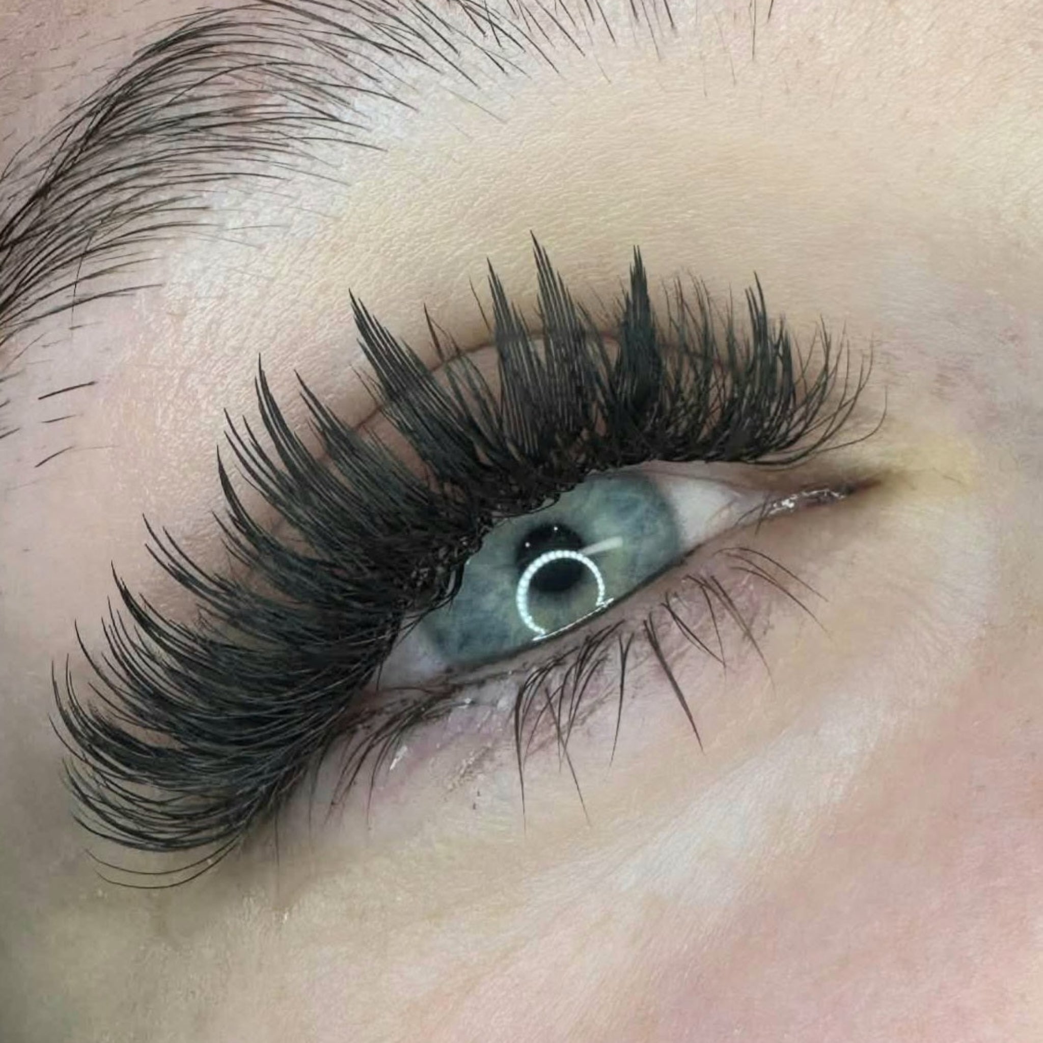 5. Completed Anime Feather lash extension set on blue-grey eyes showing dramatic feather spike volume and wispy separation from overhead angle