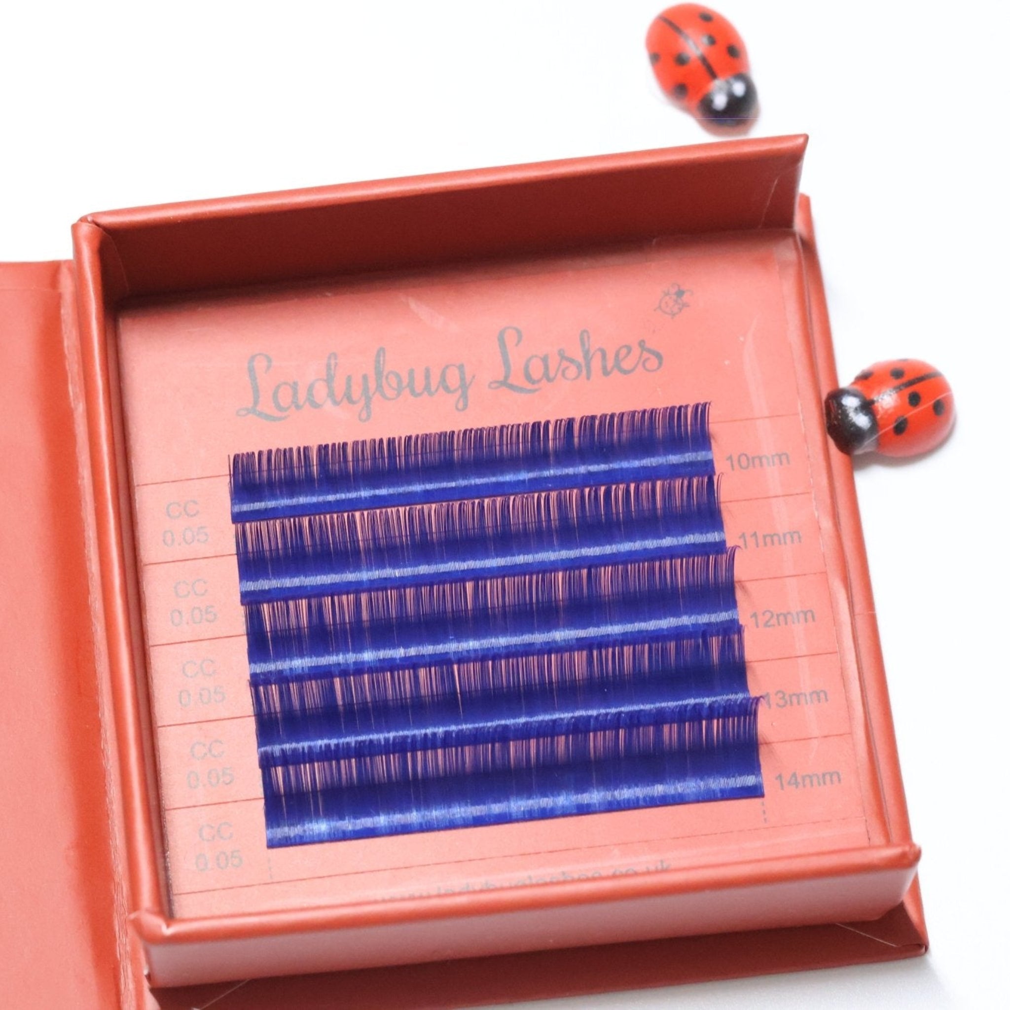 Ladybug Lashes Colour Volume Lashes 0.05mm open tray product shot showing multiple rows of blue volume lash extensions in mixed lengths 10–14mm in a red Ladybug Lashes branded lash tray from overhead angle on white background