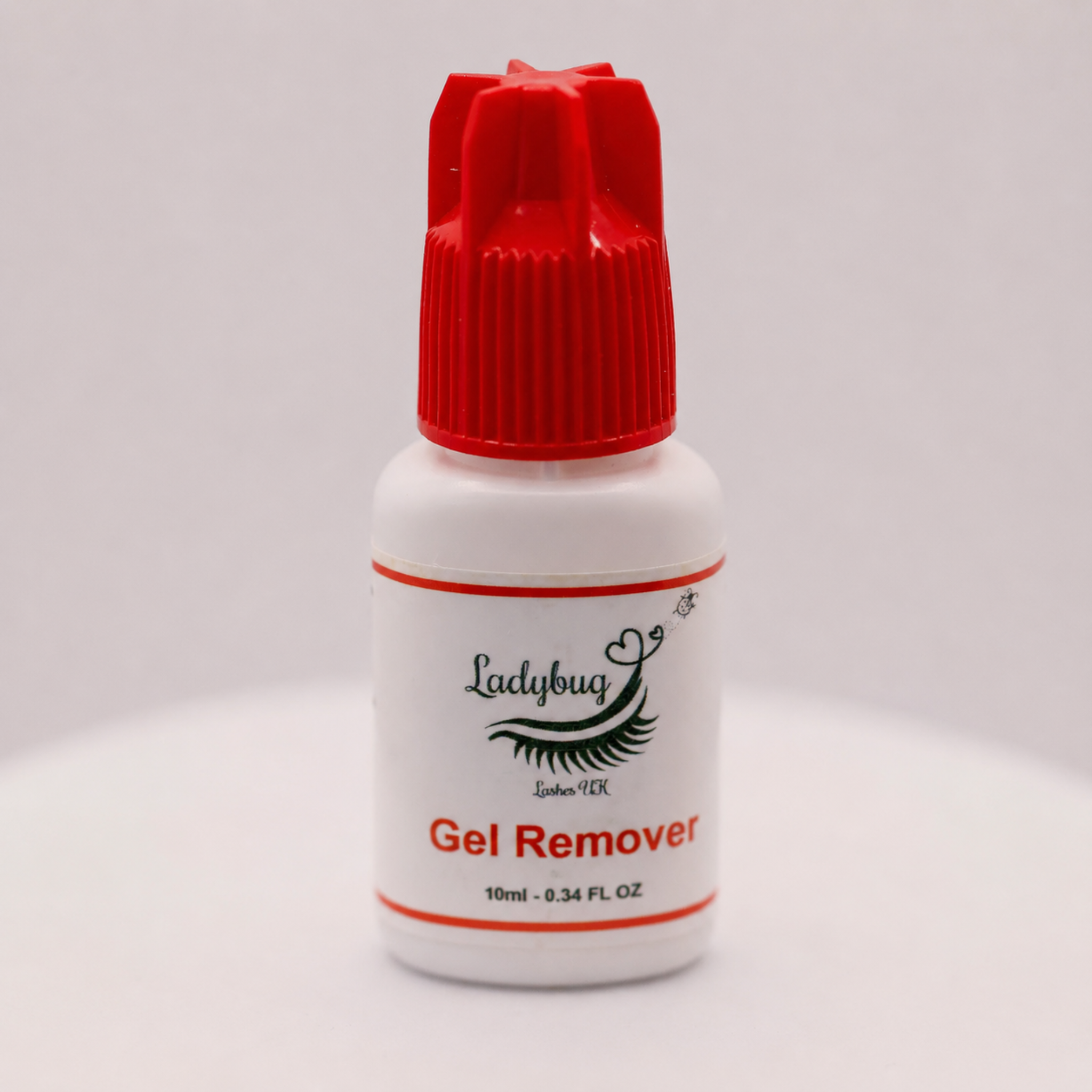 Ladybug Lashes Gentle Gel Lash Remover 10ml white bottle with red ribbed cap showing product label with Ladybug Lashes UK Gel Remover branding and 10ml 0.34 FL OZ size detail, photographed straight-on against a light grey background
