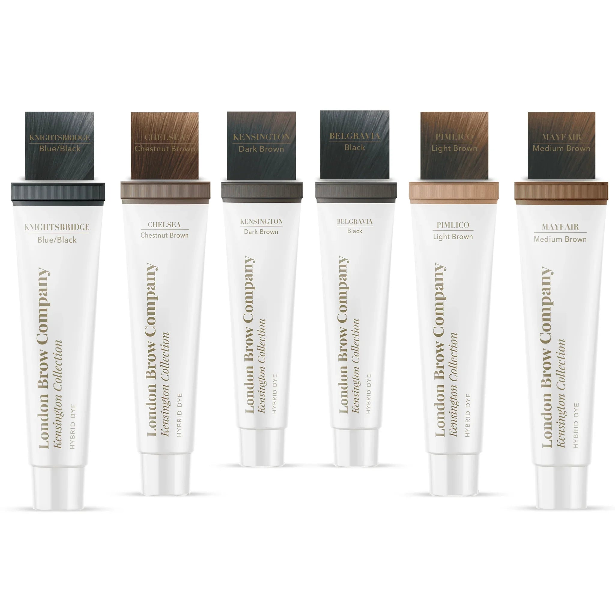 The London Brow Company Kensington Collection Hybrid Dye lifestyle shot showing multiple shade tubes arranged with developer bottle mixing dish and brush on white marble surface from diagonal angle