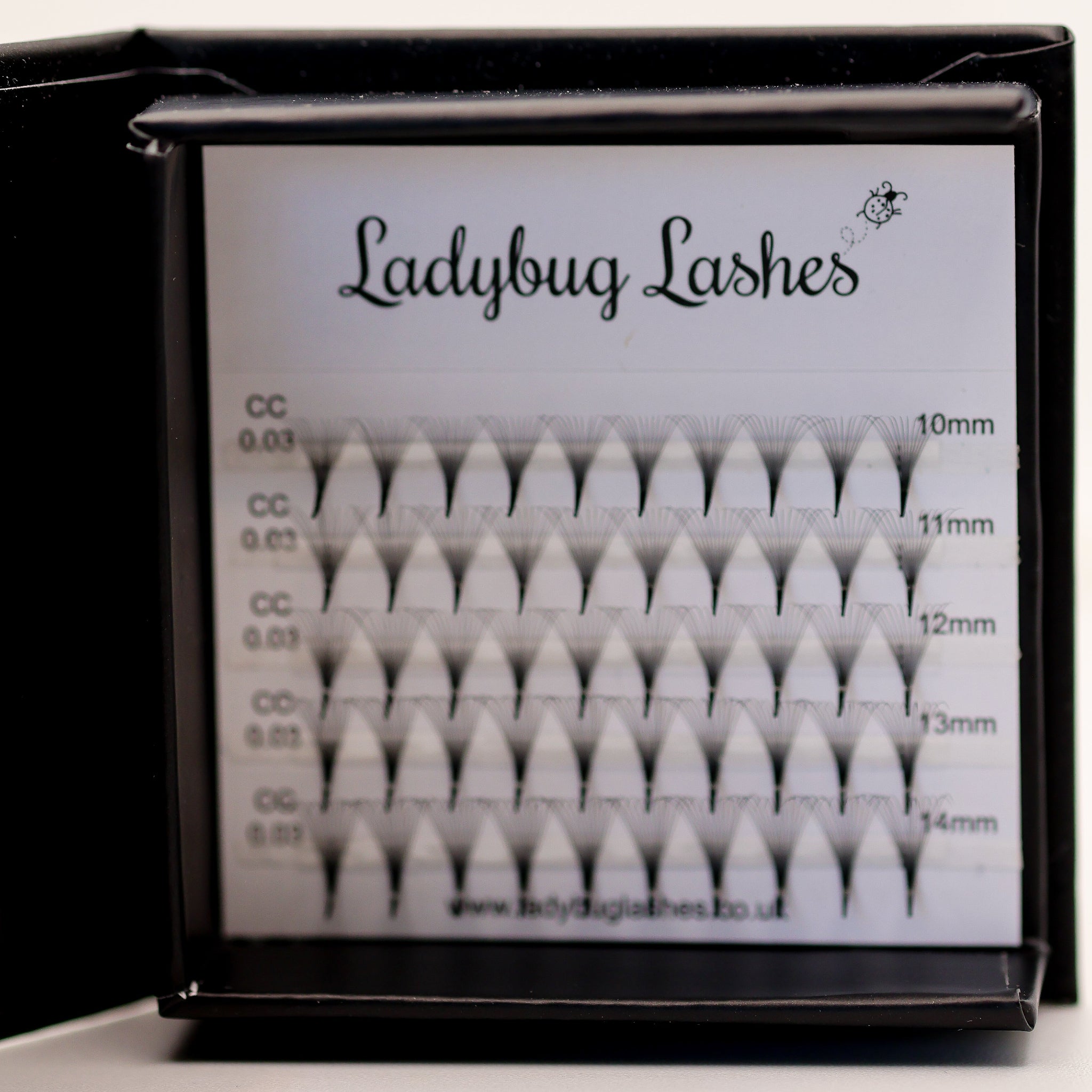 Ladybug Lashes Sample Tray Platinum Promade Ultra Black in open branded box showing full range of ultra black promade fans angled side view