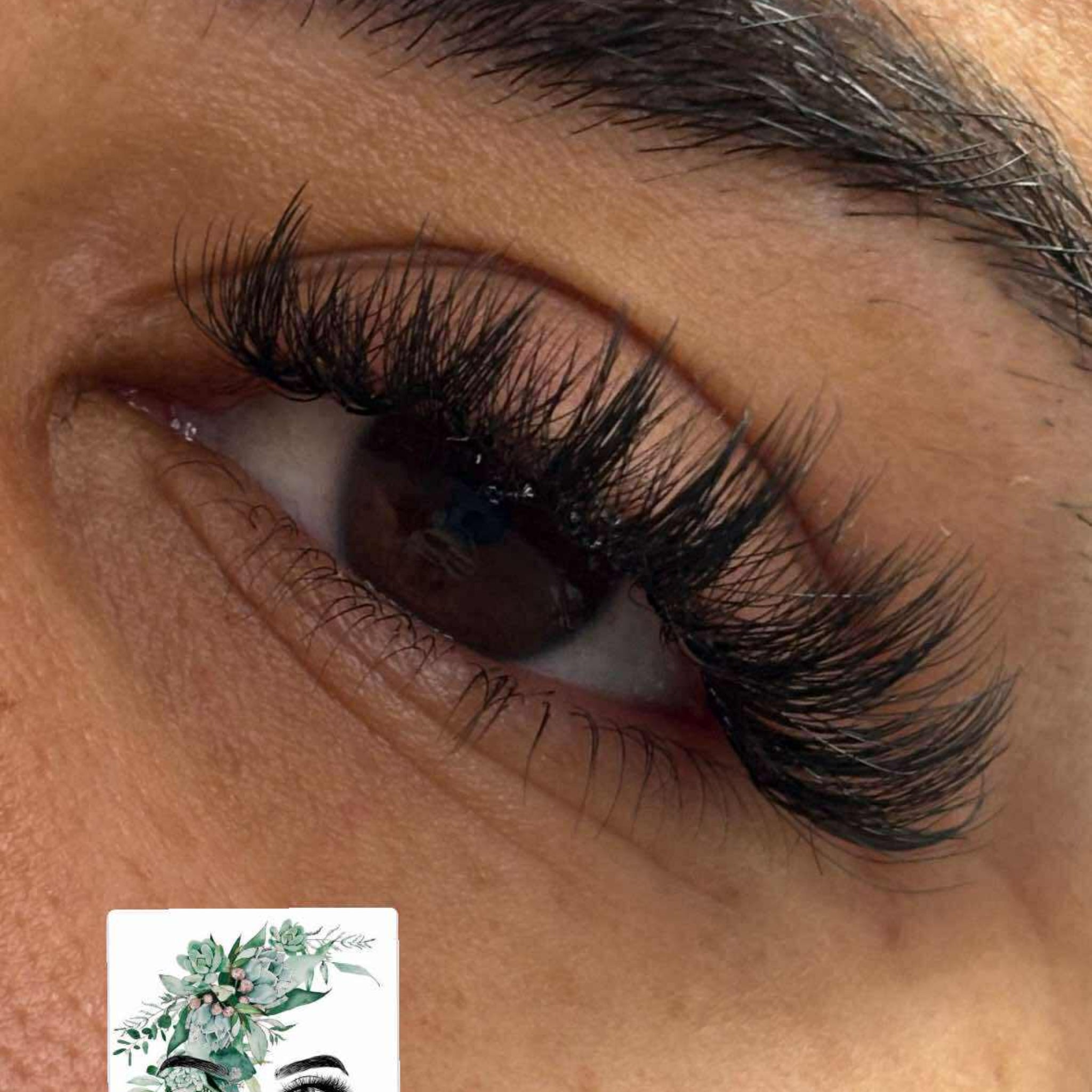 Close-up of Anime Feather lash extension set on brown eye showing dramatic feather spike volume with Radiant Lashes branded card visible