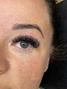 Close-up of a person's eye with long, dark eyelashes.