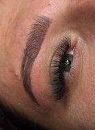 Close-up of an eye with long, dark eyelashes and a well-groomed eyebrow.
