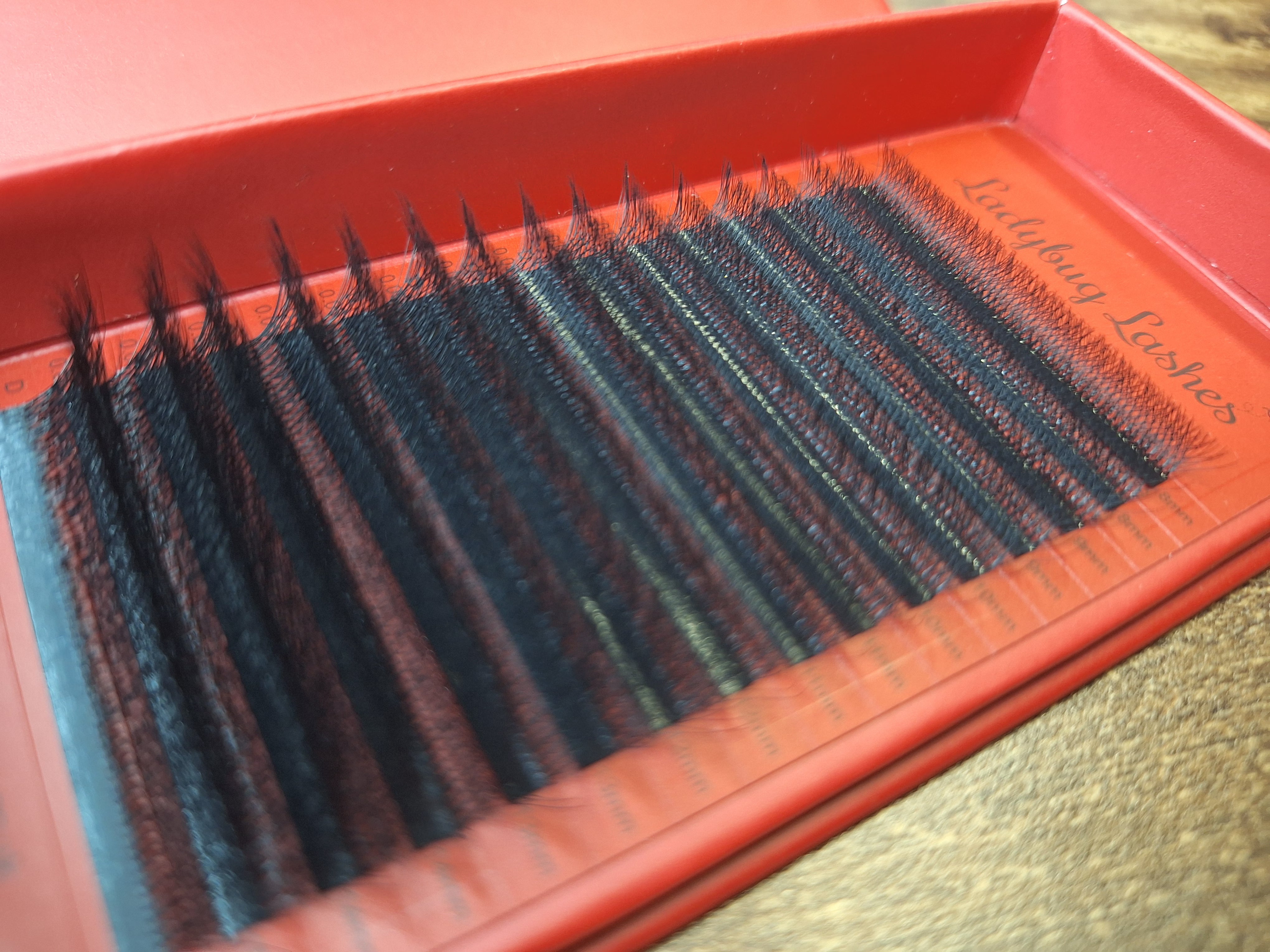 Set of false eyelashes in a red case on a textured surface