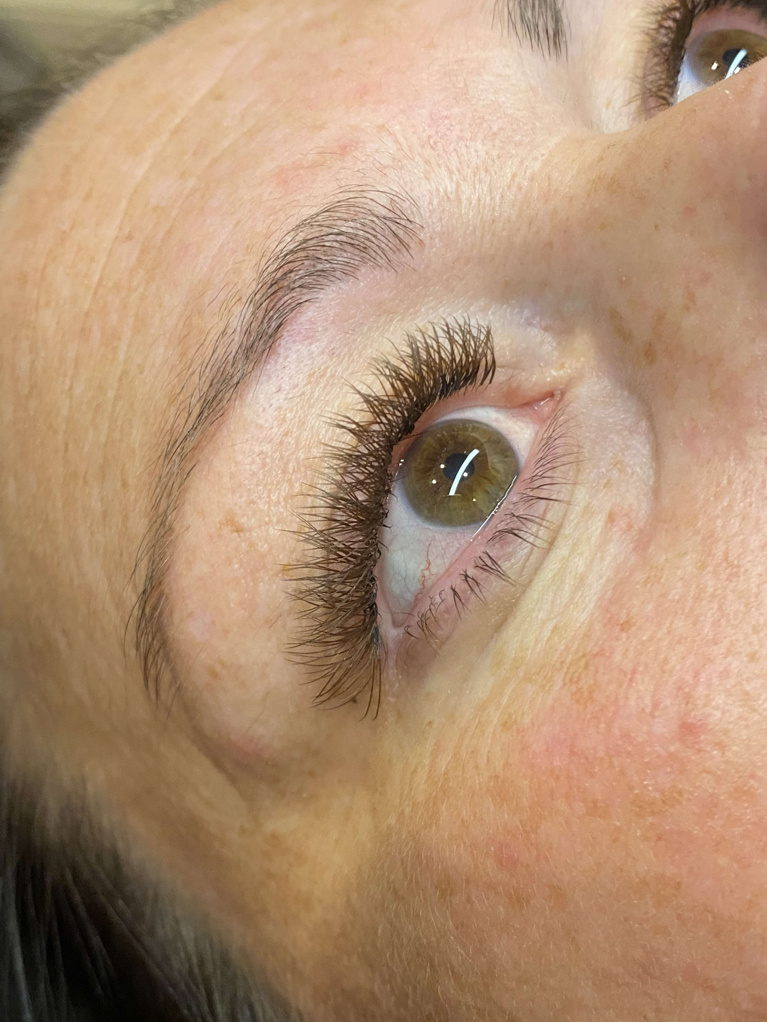 Close-up of a person's eye with visible eyelashes and skin texture.