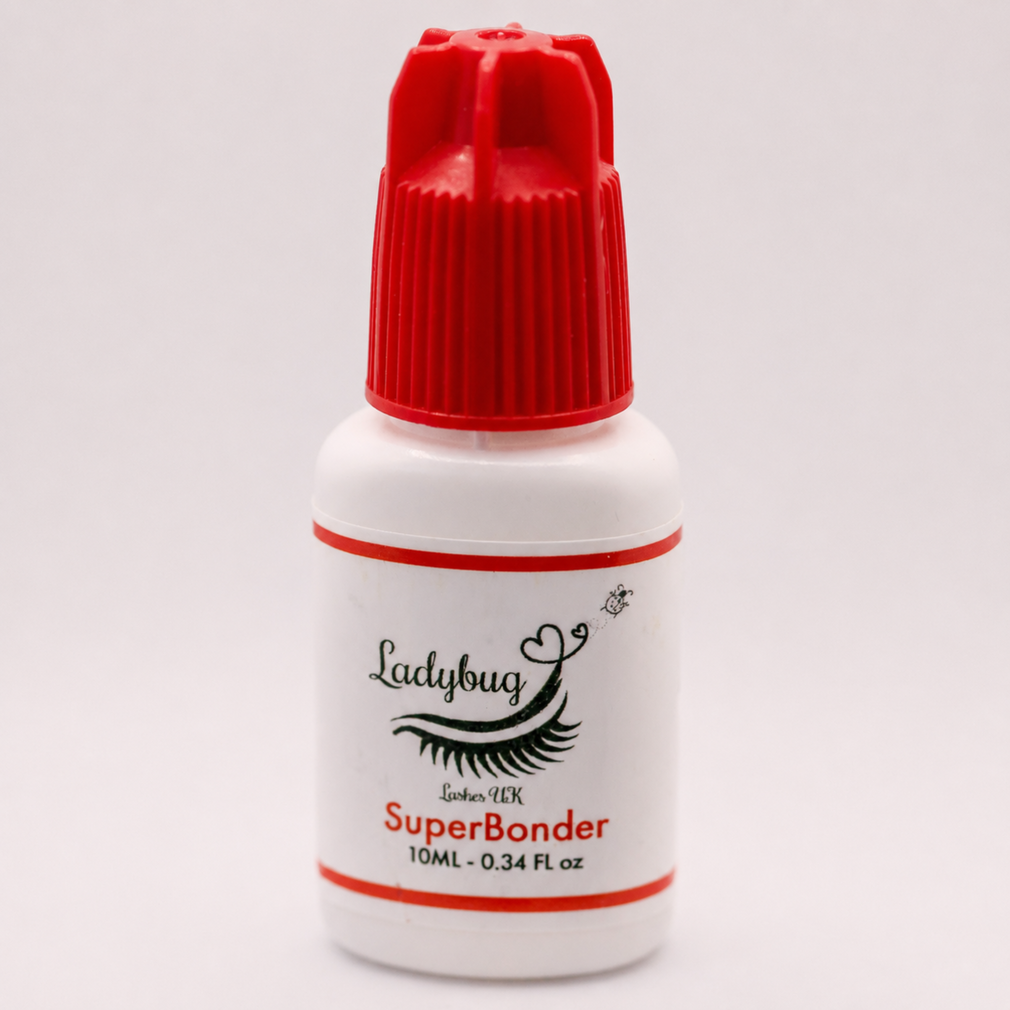 Ladybug Lashes SuperBonder 10ml white plastic bottle with red cap showing product label with Ladybug Lashes UK SuperBonder branding and 10ML 0.34 FL oz size detail on a light grey background
