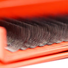 Close-up of Ladybug Lashes 10D Clover lash row tips showing wispy fan texture and curl definition against red box