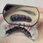 Completed Ladybug Lashes YY and Tinsel lash set on blue-grey eye showing full volume with iridescent blue tinsel fibres from front angle
