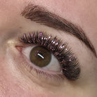 Completed Ladybug Lashes YY and Tinsel lash set shown in mirror during application with iridescent purple and holographic shimmer fibres visible