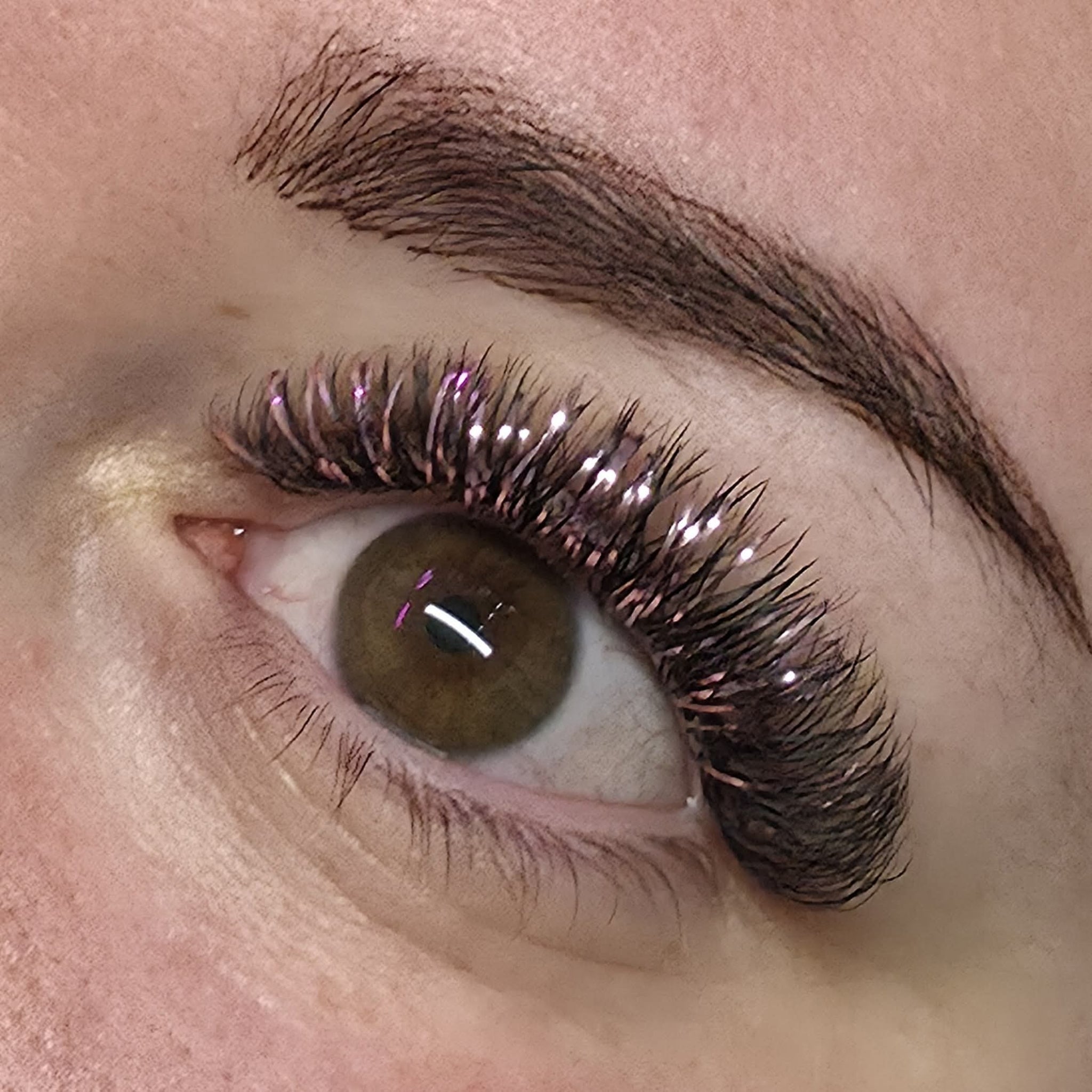 Completed Ladybug Lashes YY and Tinsel lash set shown in mirror during application with iridescent purple and holographic shimmer fibres visible
