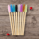 Set of colourful spoolies with wooden handles on a wooden surface