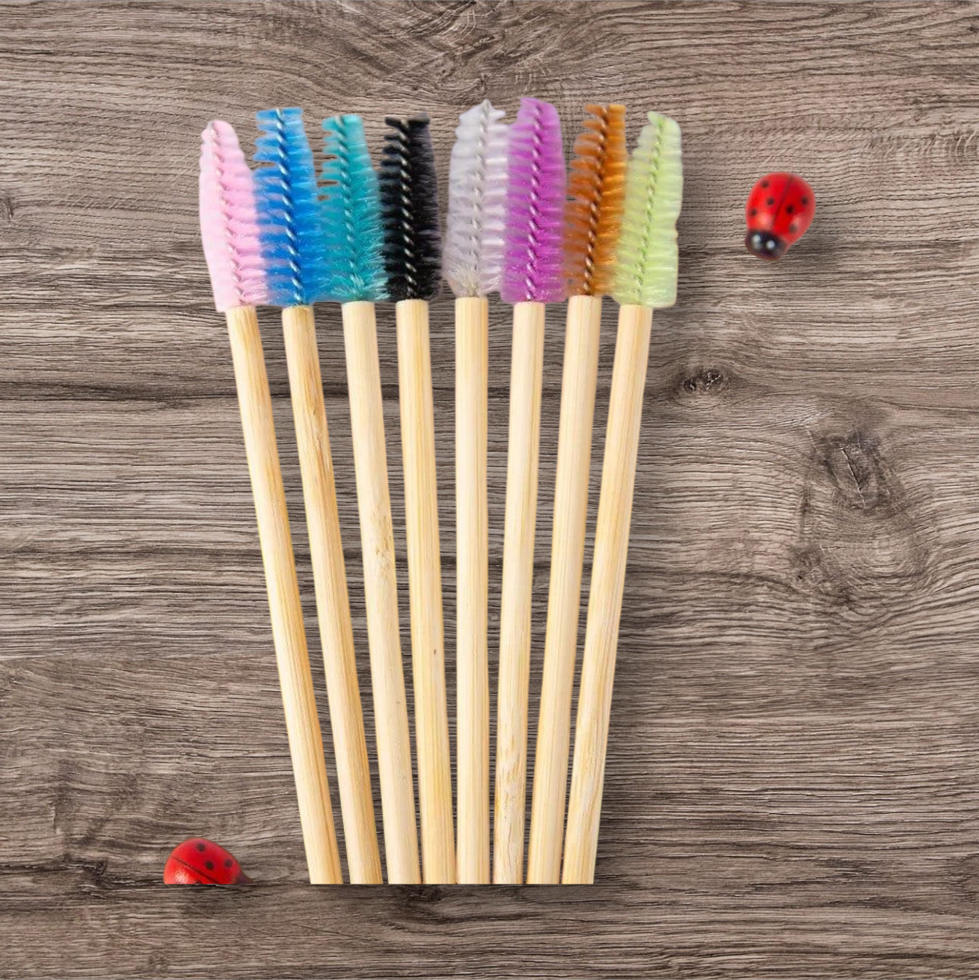 Set of colourful spoolies with wooden handles on a wooden surface