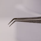 Close-up of LADYBUGLASHES Angled Volume Tweezers – silver fibre grip tip detail