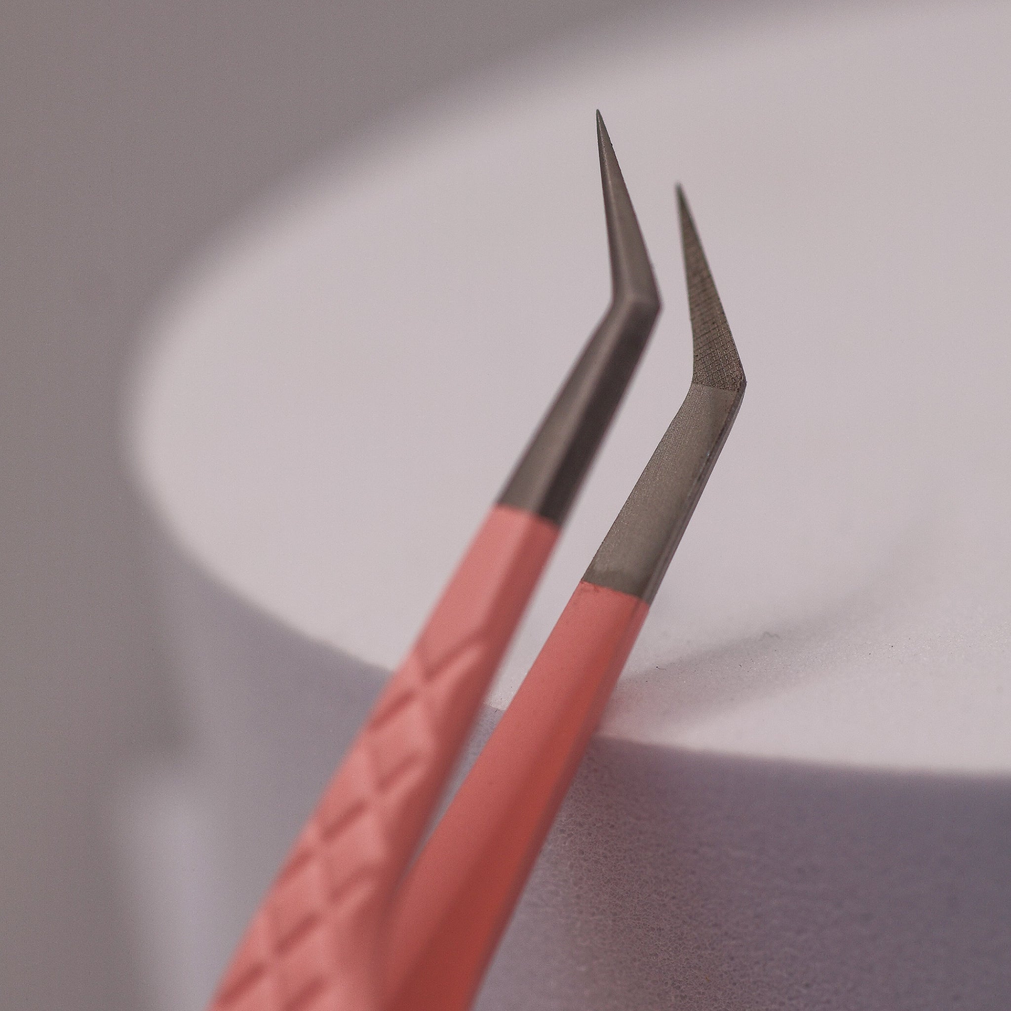 Close-up of LADYBUGLASHES Angled Volume Tweezers – pink fibre grip tip detail