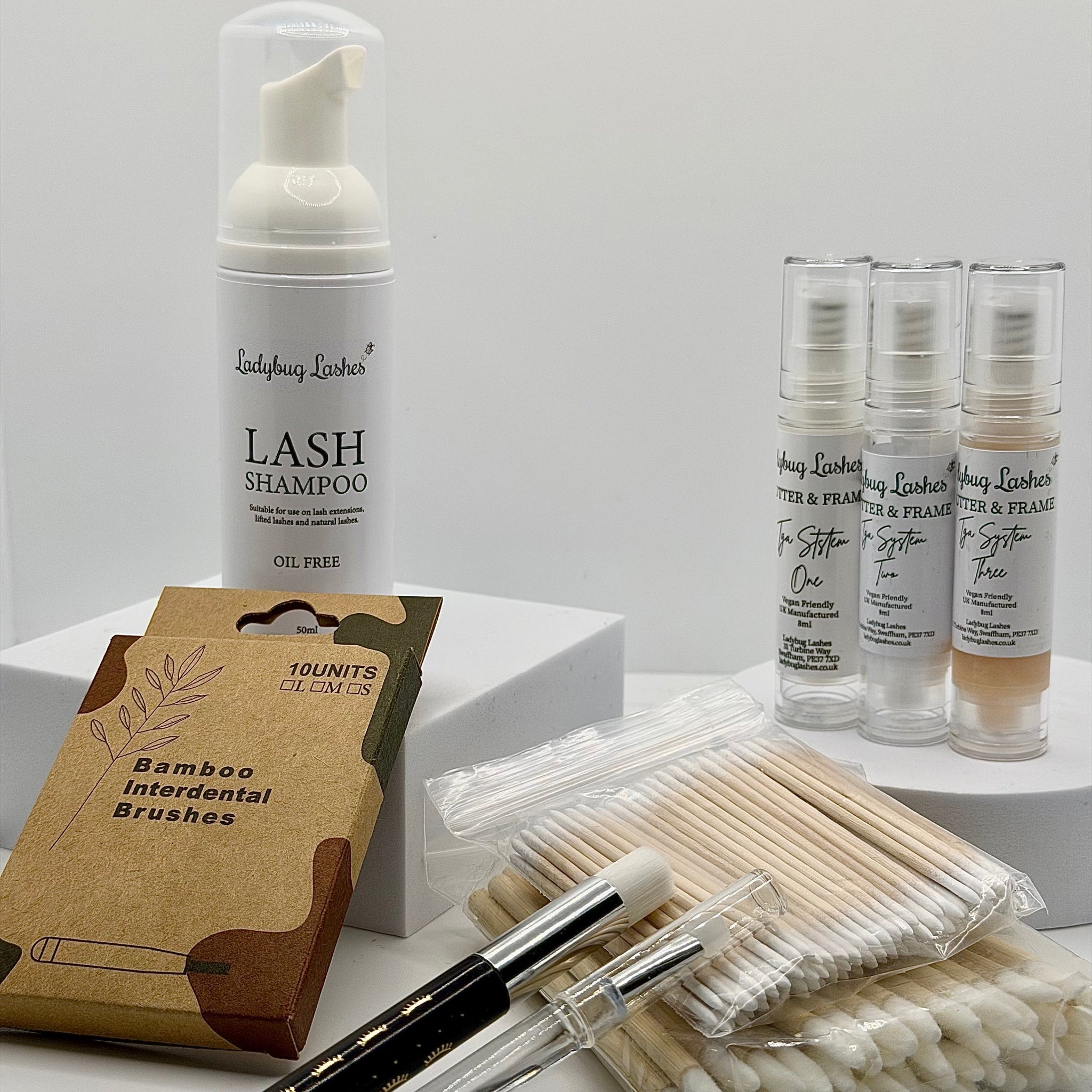 Ladybug Lashes Flutter and Frame TGA System Brow Lamination Kit flatlay showing Ladybug Lashes Lash Shampoo 50ml foam pump, three Flutter and Frame TGA System airless pump bottles One Two and Three, bamboo interdental brushes pack, cotton buds and microfibre brushes on white background
