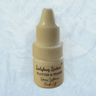 Small beige bottle labeled 'Ladybug Lashes Flutter & Frame' on a light blue textured background