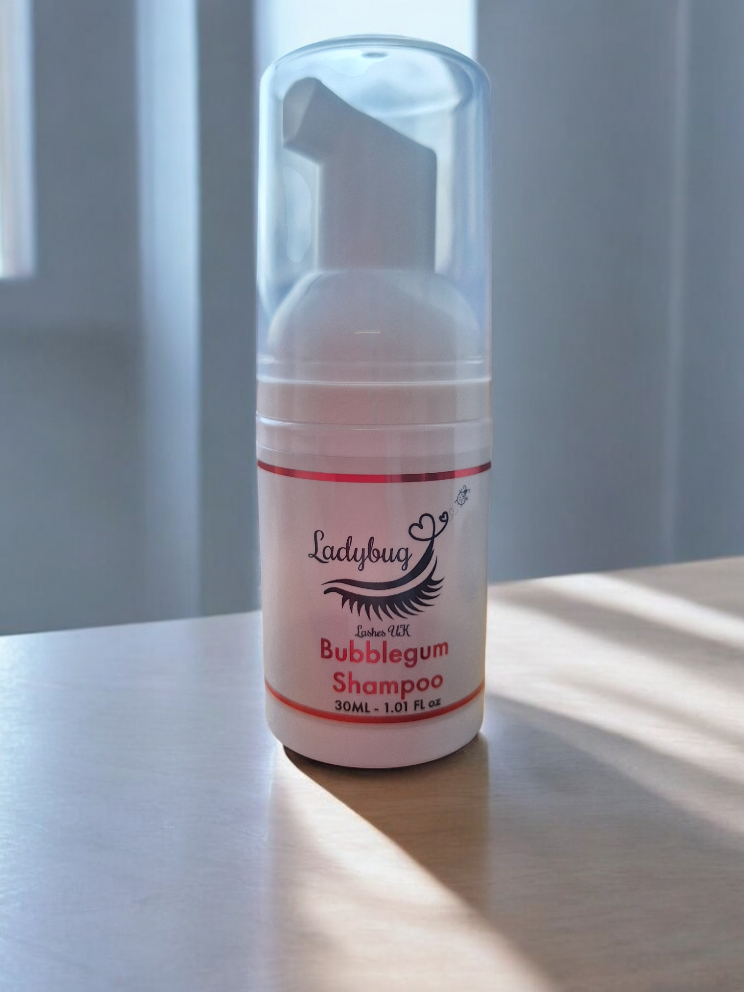 A pump bottle of Ladybug brand lash shampoo with bubble gum scent, containing 30ml of liquid.