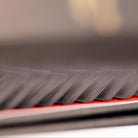 Extreme macro angled close-up of L curl lash extensions on red Ladybug Lashes tray showing individual lash separation and flat L curl base detail