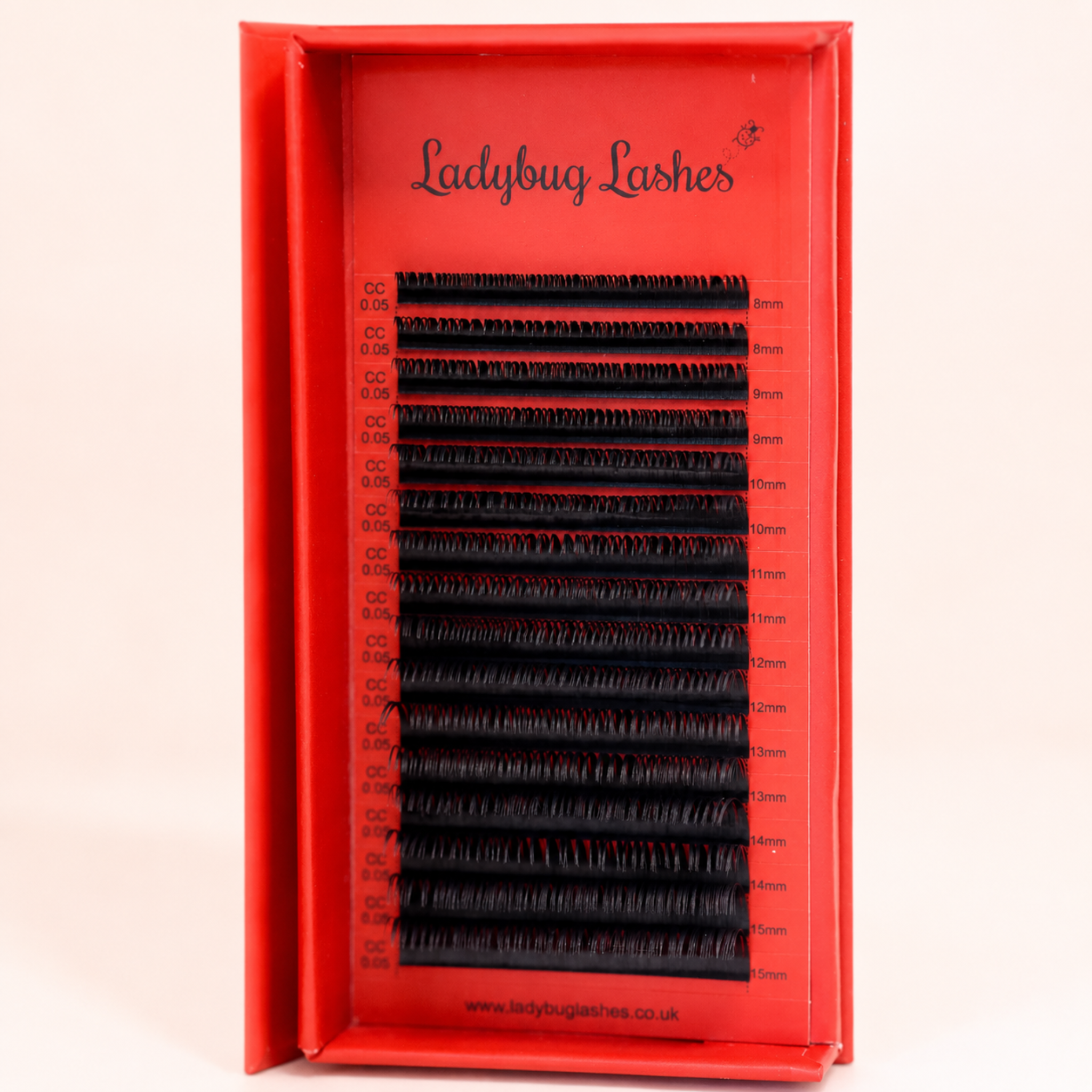 Ladybug Lashes Wet Look lash mixed tray in open branded box showing full strip of glossy wet look lash extensions angled side view