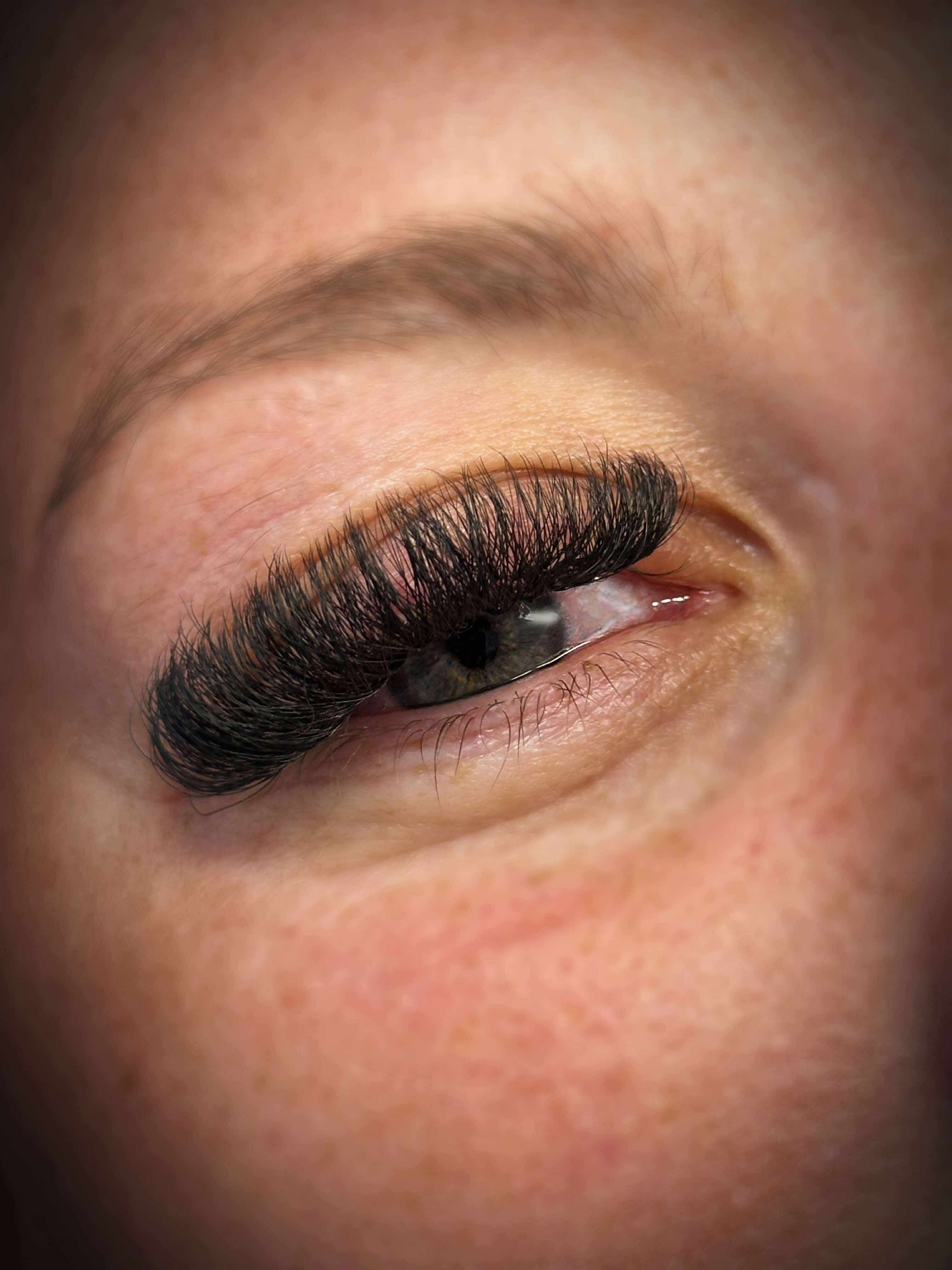 Close-up of a person's eye with long, dark eyelashes.