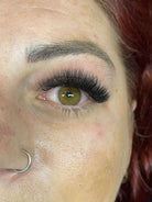 Close-up of a person's eye with false eyelashes and red hair.