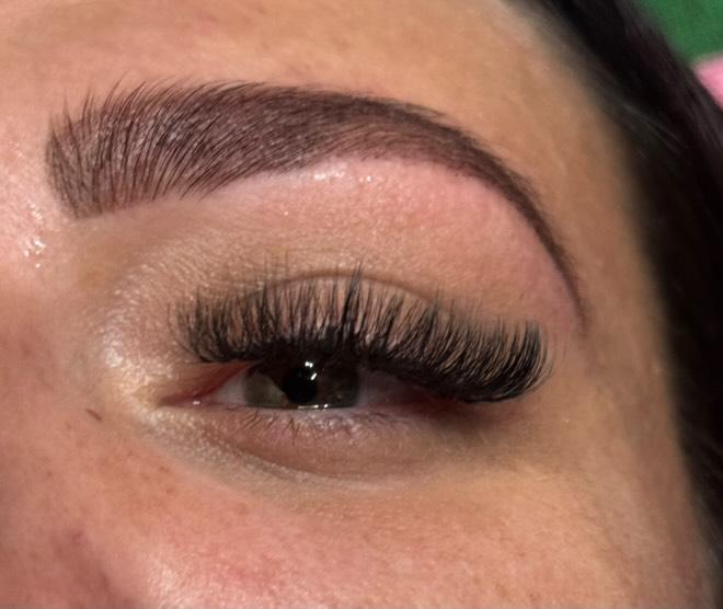 Close-up of an eye with long, dark eyelashes and a well-groomed eyebrow.