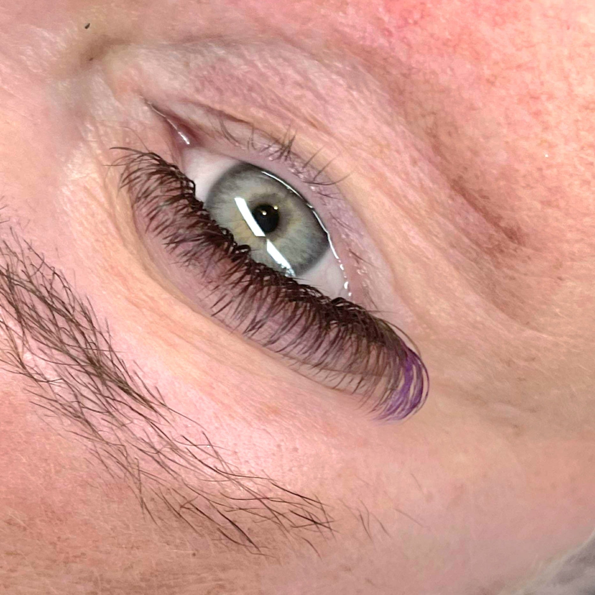Ladybug Lashes Colour Volume Lashes application result lifestyle portrait showing two fair-skinned women with blonde and green-tinted hair wearing dramatic black volume lash extensions with purple colour tips from front angle
