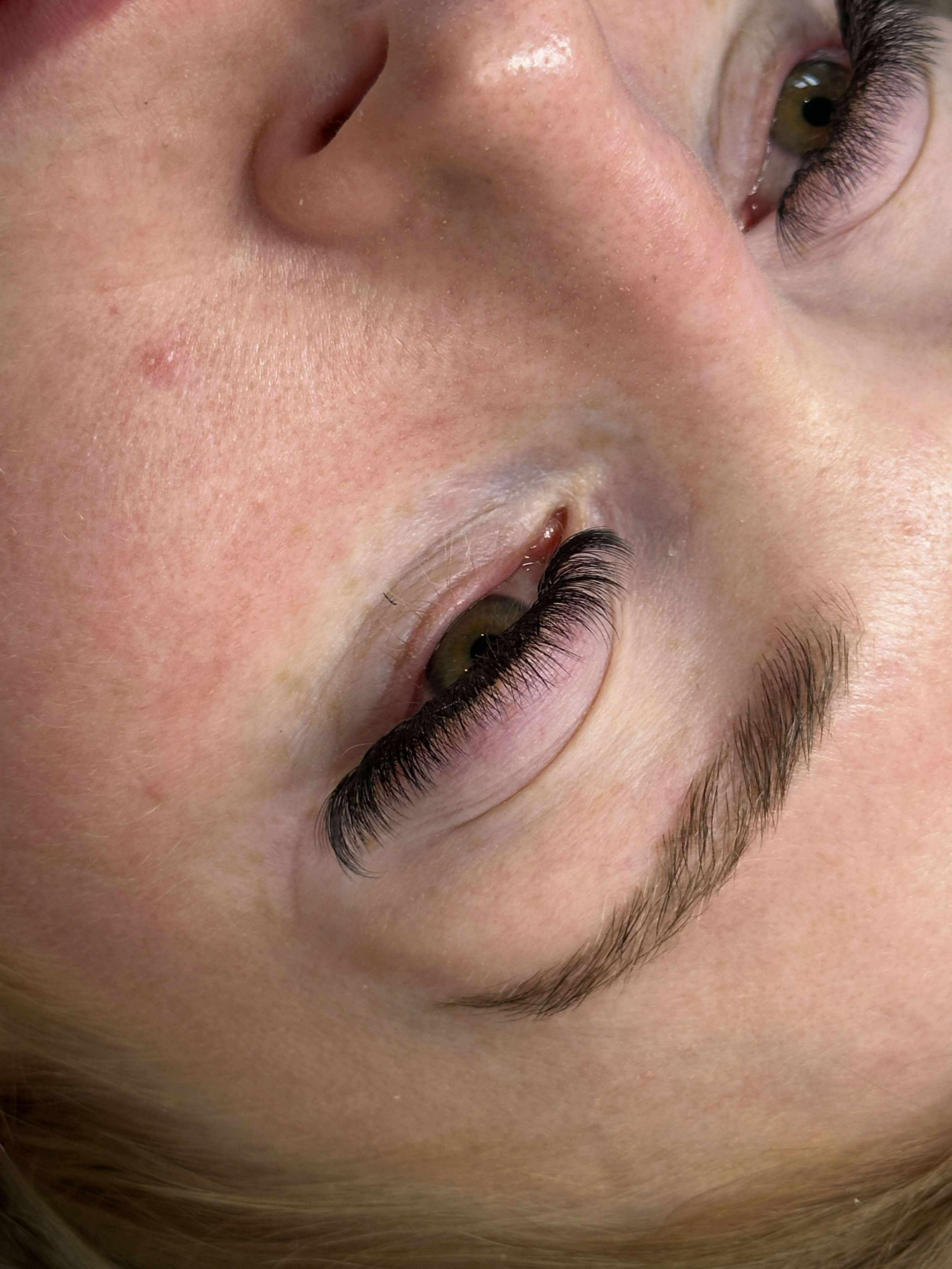 Close-up of a person's eye with visible eyelashes and eyebrow.