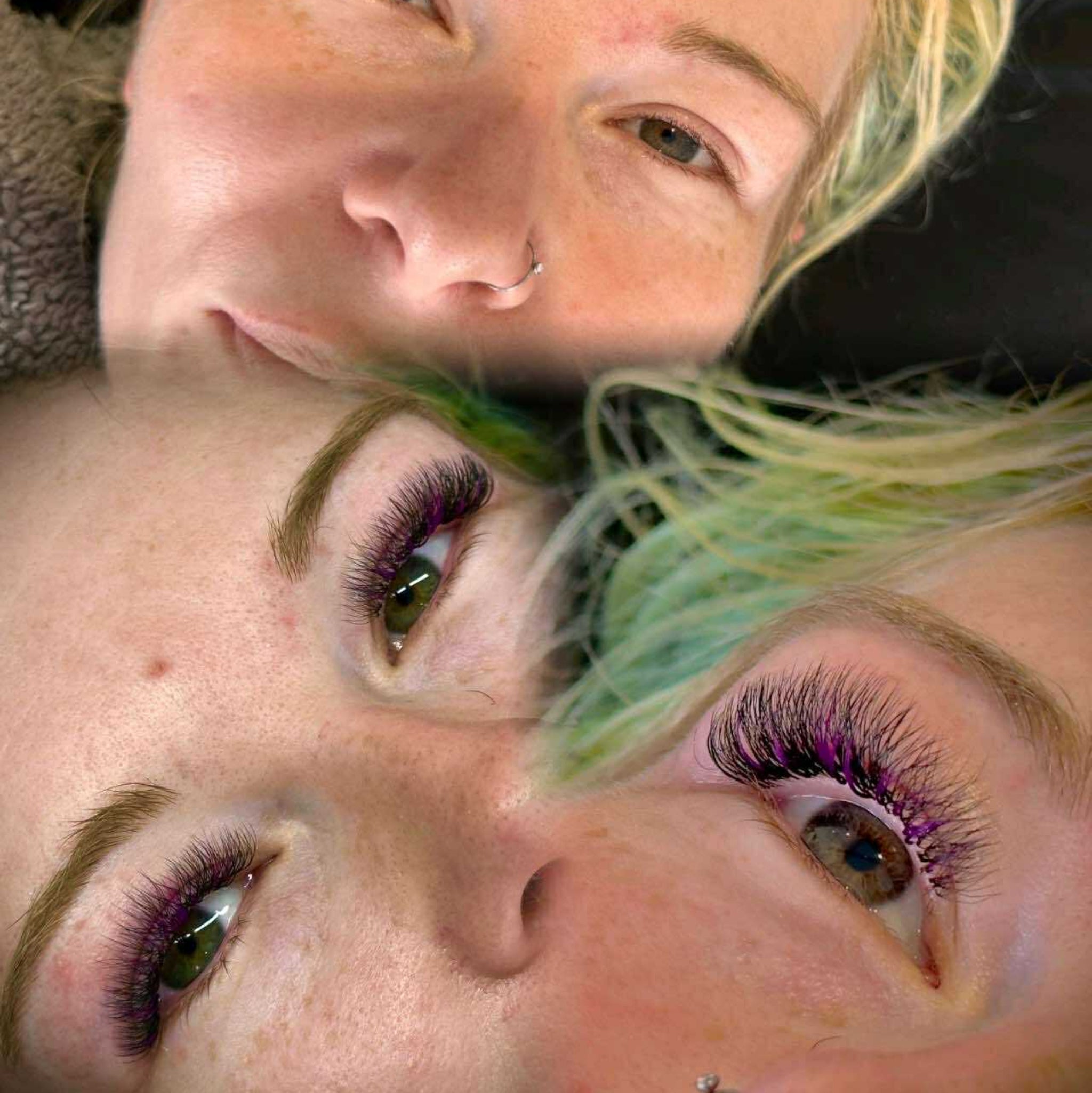 Ladybug Lashes Colour Volume Lashes application result lifestyle portrait showing two fair-skinned women with blonde and green-tinted hair wearing dramatic black volume lash extensions with purple colour tips from front angle