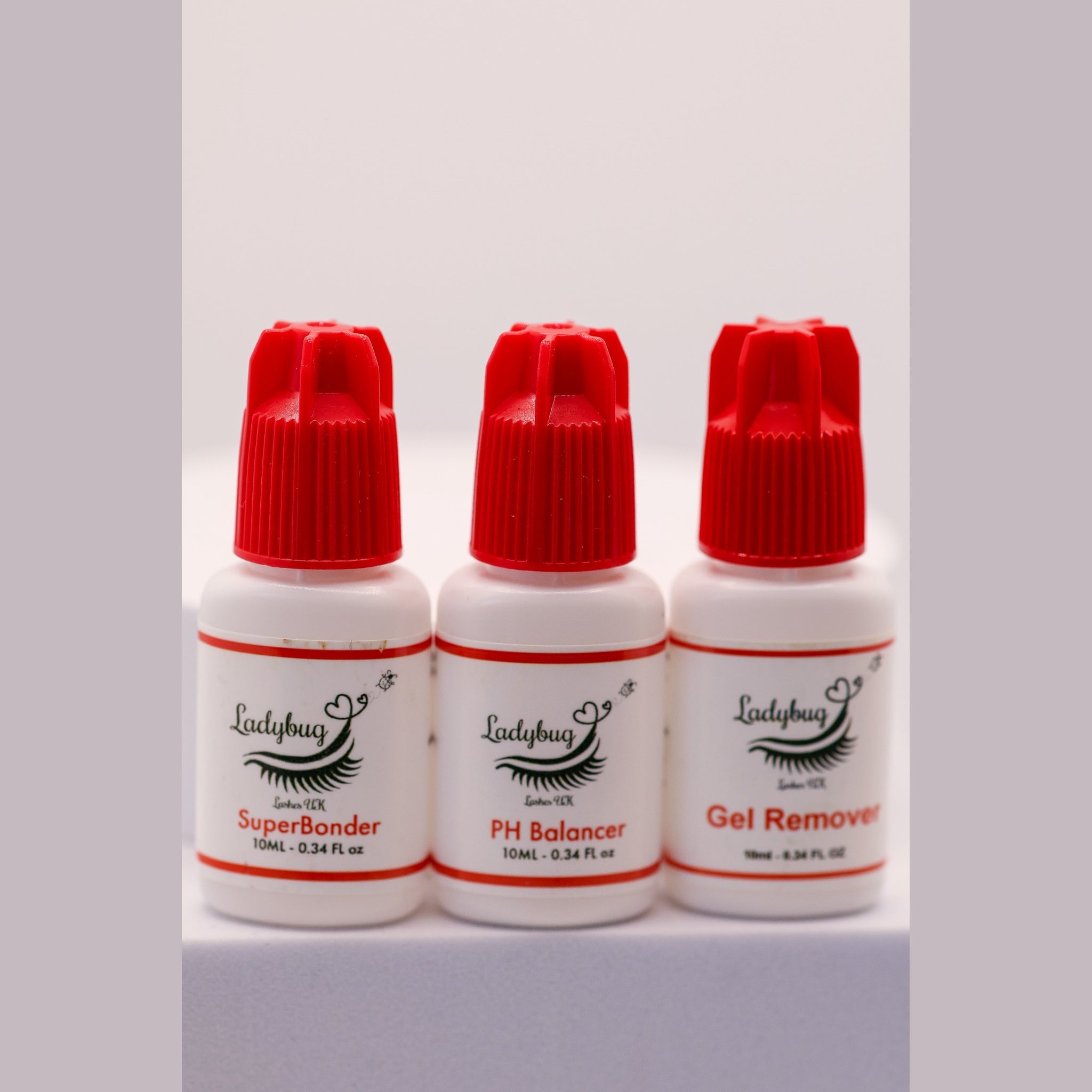 Ladybug Lashes Superbonder, PH Balancer and Gel Remover Bundle showing three products on a white background: SuperBonder 10ml clear glass dropper with silver and white pipette cap, PH Balancer 10ml white bottle with red cap, and Gel Remover 10ml white bottle with red cap, all with Ladybug Lashes UK branding